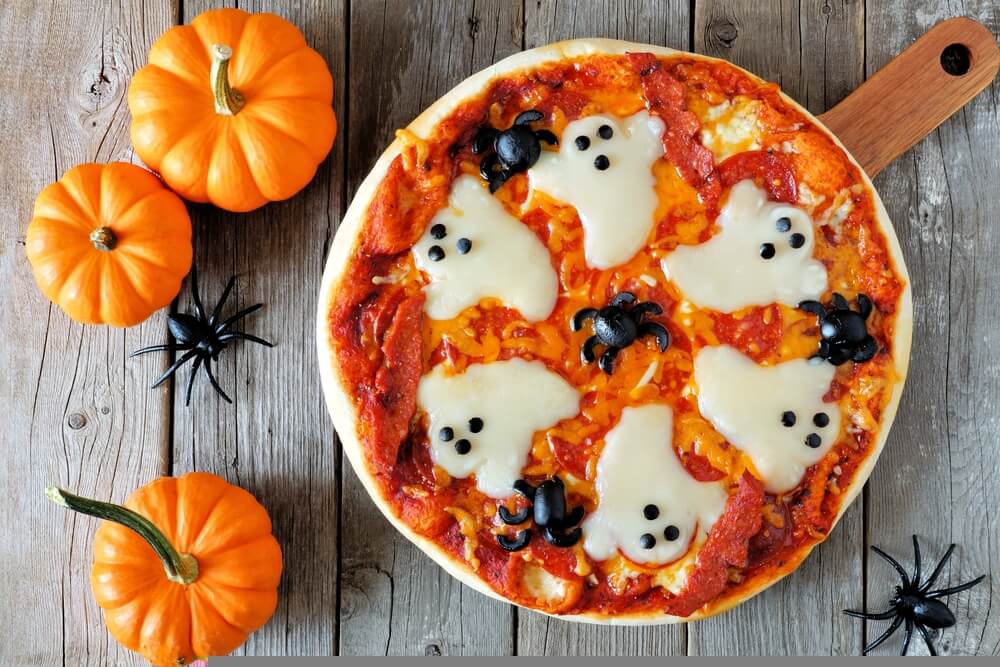 a cheese and tomato pizza with cheese ghosts on the toppings