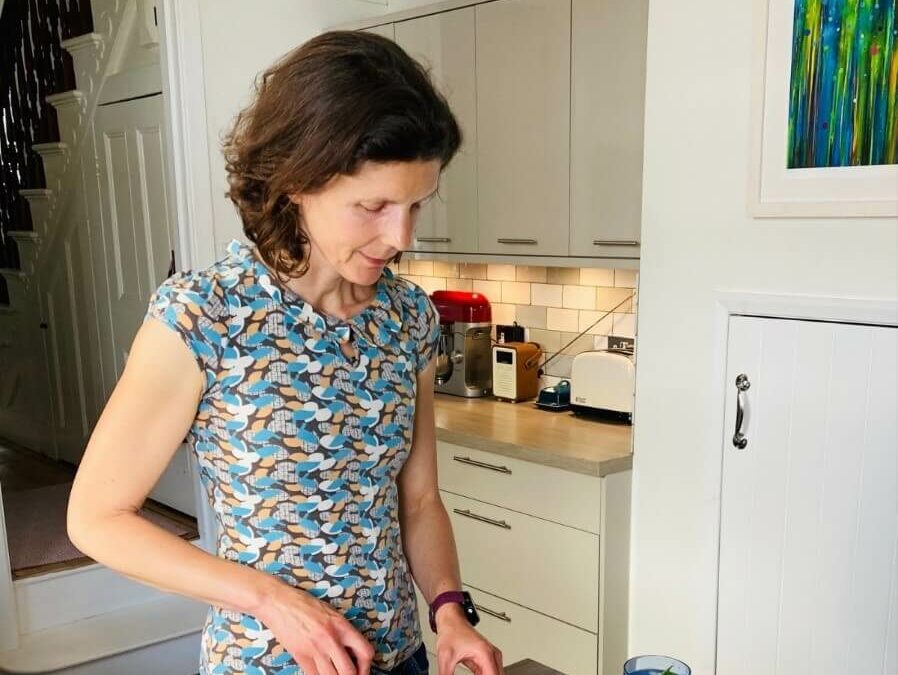 Jo Sardella chopping vegetables standing in her kitchen