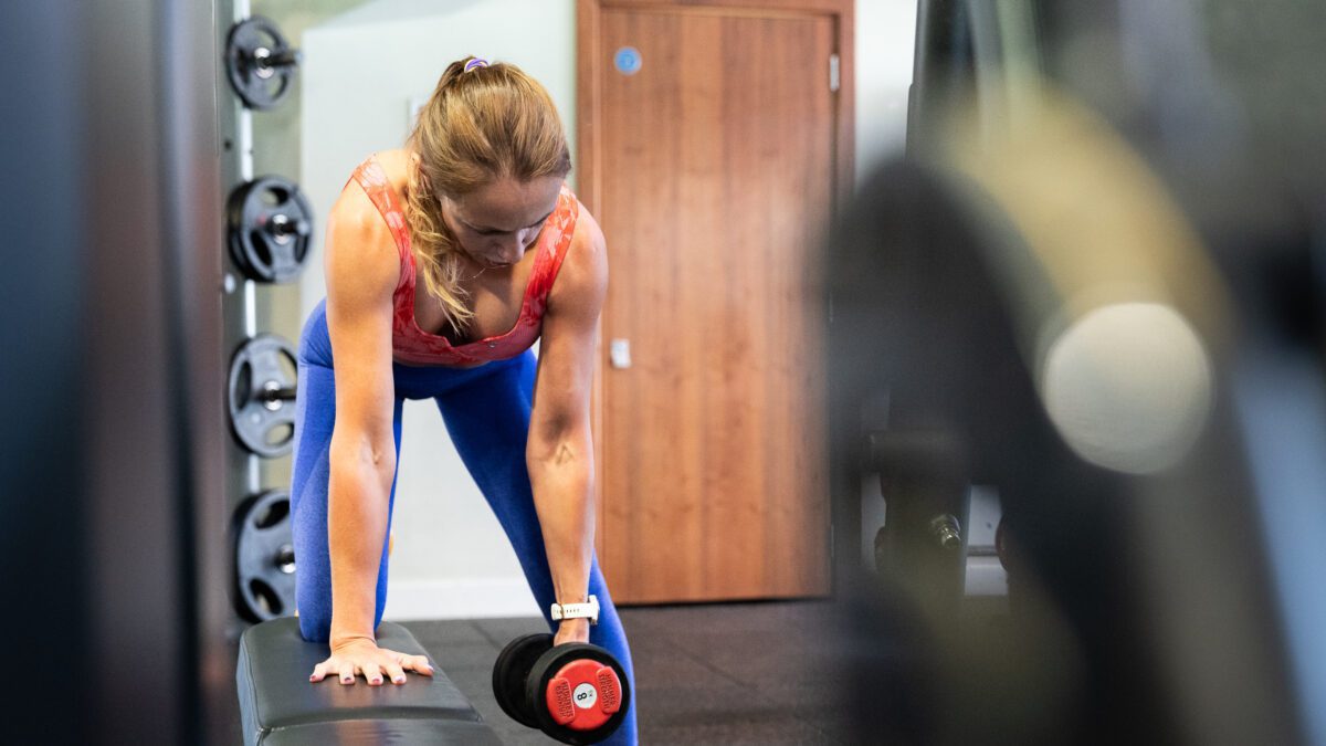 Personal trainer demonstrating dumbbell rows