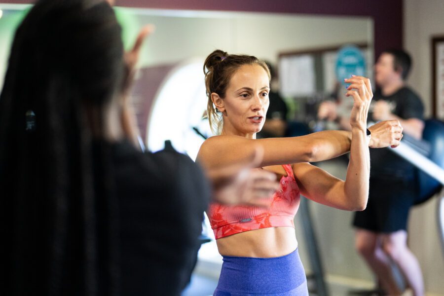 Personal training instructor leading warm up stretches