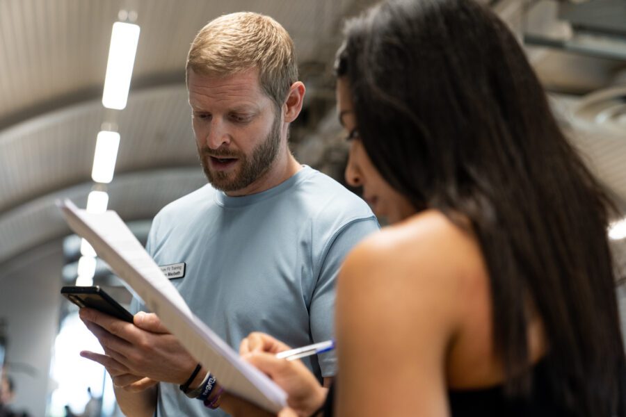 Gym instructor advising client