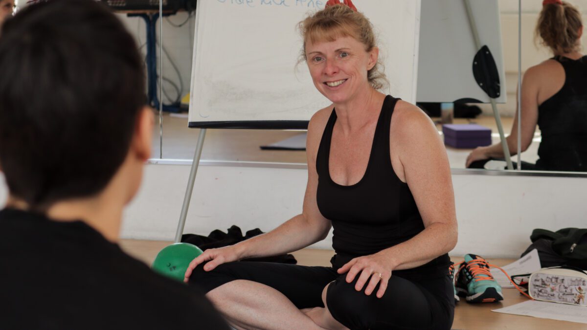 Pilates mat instructor teaching pilates class