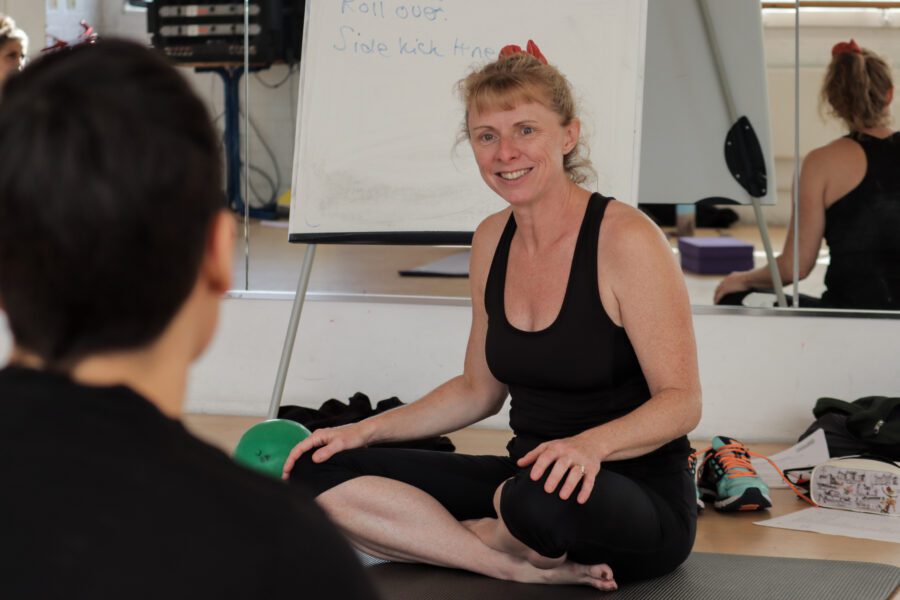 Pilates mat instructor teaching pilates class