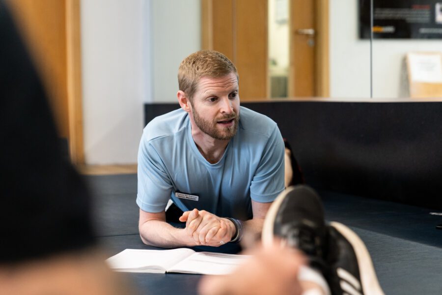 Personal training course tutor teaching students on practical learning