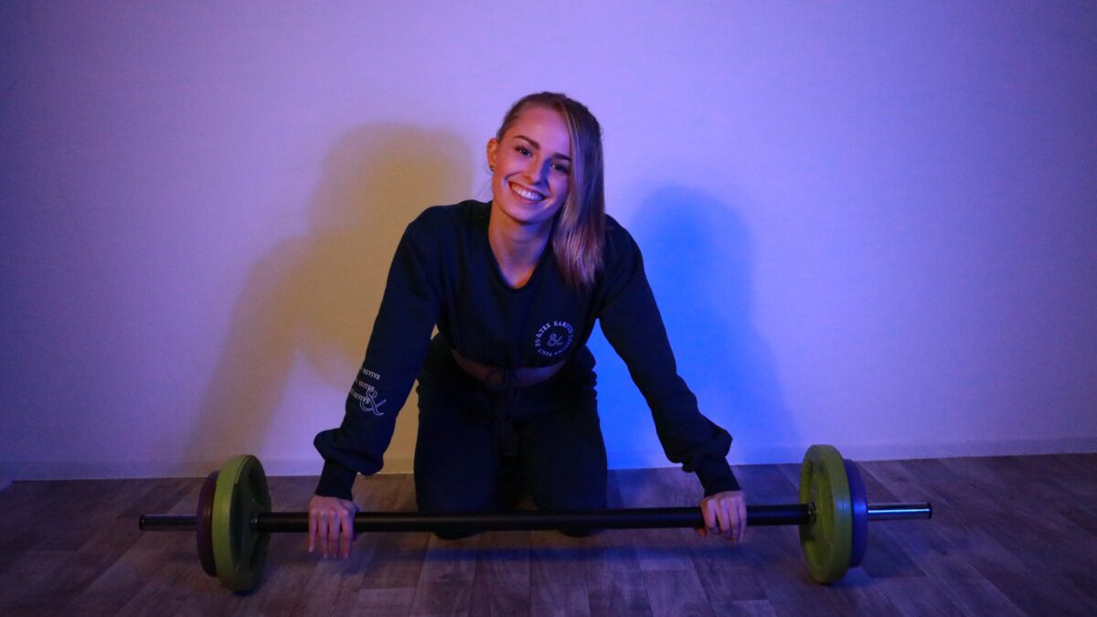 Georgia Nicholls with weights smiling at the camera