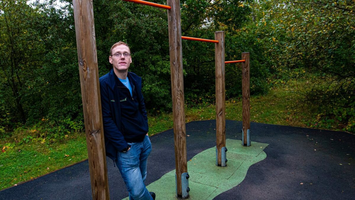 David Breaker leaning on outdoor pull up bars