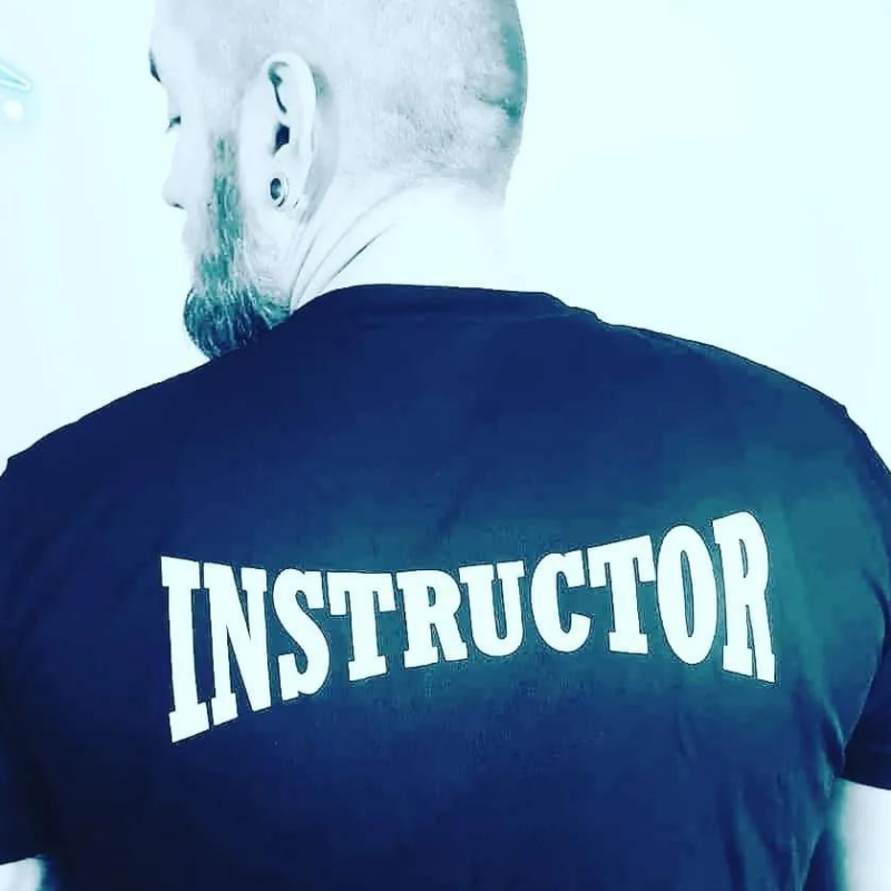 A man with his back to the camera with the word Instructor on the back