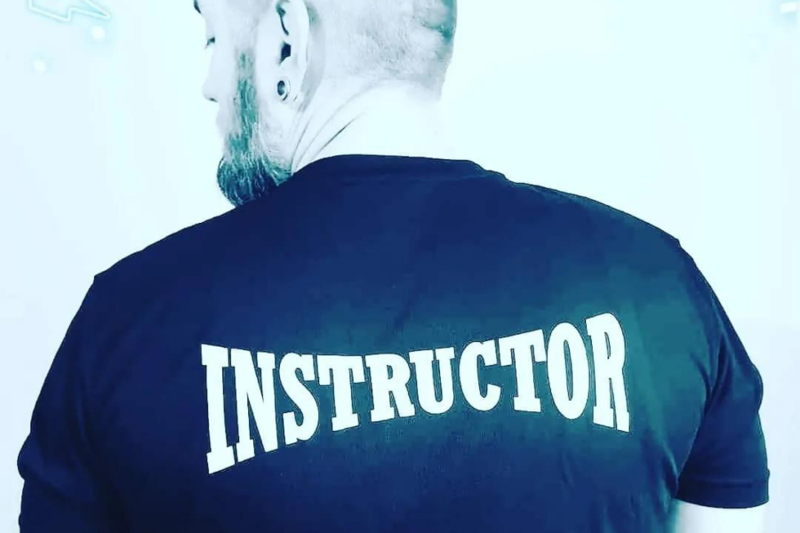 A man with his back to the camera with the word Instructor on the back