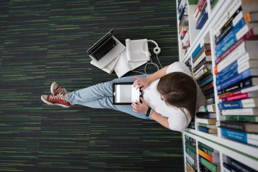 girl sitting next to books, learning and working