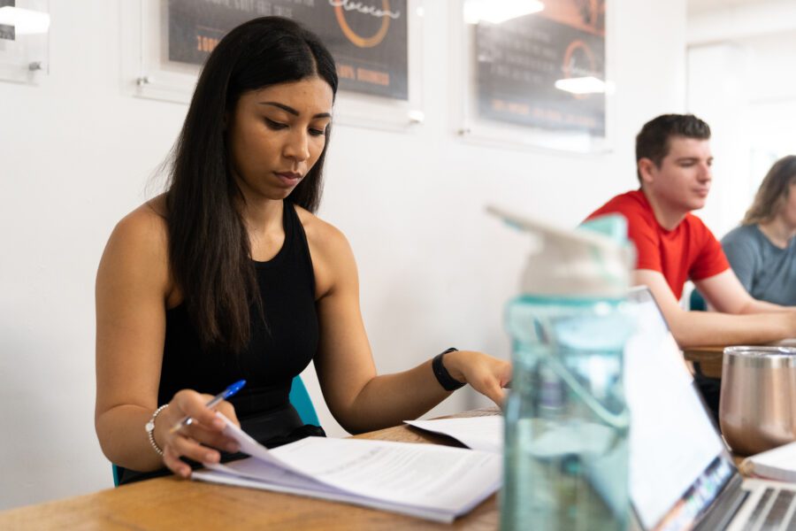 Woman learning at a table with a man in the background