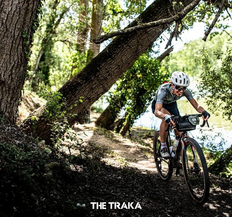 A woman riding a bike fast through a forest