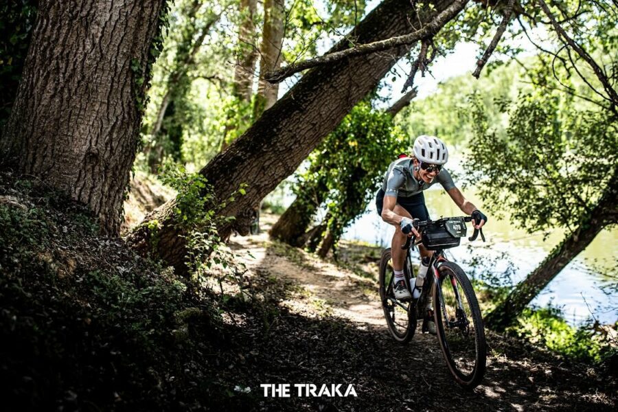 A woman riding a bike fast through a forest