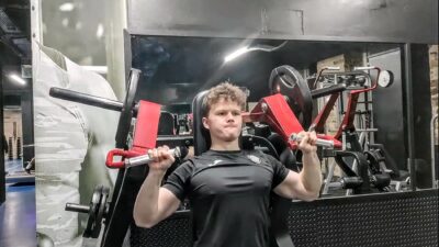 A young man in the gym using a weights machine