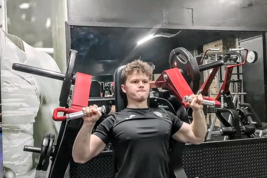 A young man in the gym using a weights machine