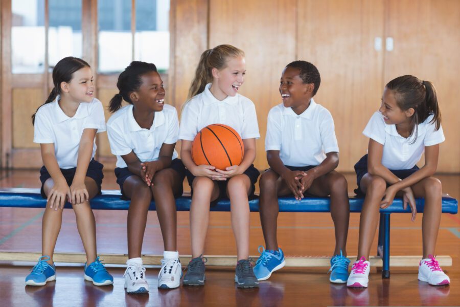 Children sitting, smiling with a ball